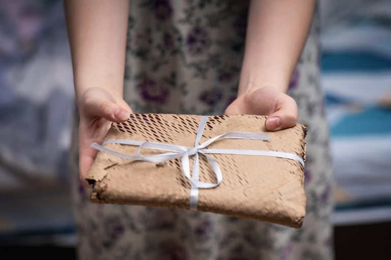 A gift-wrapped book presented in craft paper with a ribbon
